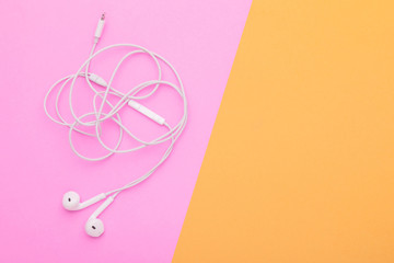 White tangle earphone on pink background. Copy space for text or design
