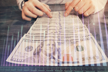 Multi exposure of forex graph drawing hologram and USA dollars bills and man hands. Technical Analysis concept.