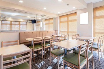 Empty tables and chairs inside a small breakfast room in the hotel
