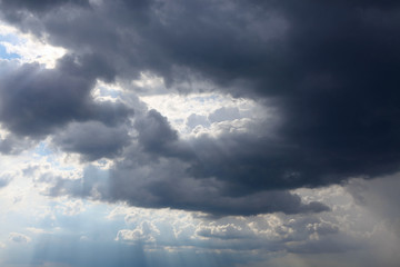 Hole in the sky . Black clouds with sunshine