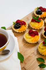 fruit tartlets being served with a cup of tea