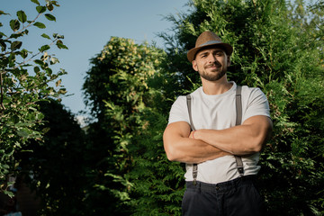 happy gardener young European man . the background of green trees