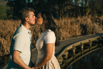 Couple kissing on beautiful outdoor setting during sunset. Romanticism concept
