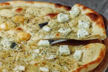 four cheese pizza, italian pizza. pizza stuffed with four varieties of cheese on a gray background.