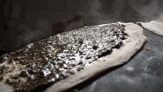 Close Up of Hot Traditional Arab Pita Bread With Spread. Manakeesh or Manoushi. Slow Motion of Baking Steam