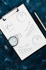 business analysis and statistics, desk with mixed graphs and charts on clipboard