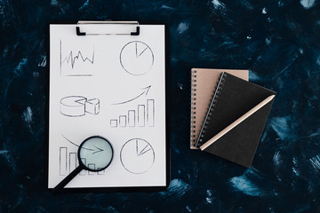 business analysis and statistics, desk with mixed graphs and charts on clipboard