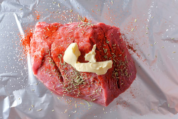 Slice of raw meat with spices on the folding