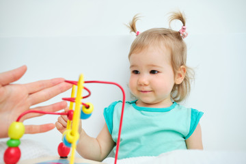 toddler happy playing with a toy and a parent.