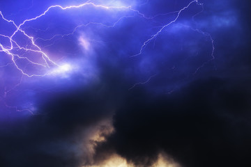 Purple stormy sky with thick dark clouds and bright lightning discharges. Aesthetic background for design with thunder clouds and lightning strikes.