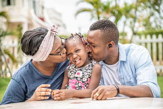 African father and mother kiss daughter, Happy family