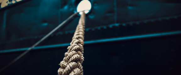 Rope that tied the ship close-up on the background of the ship's side.