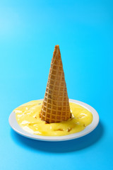 side view durian flavor ice cone melted on a dish on blue background