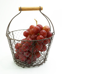 Close-Up Of A Basket Of Red Grapes Against White Background
