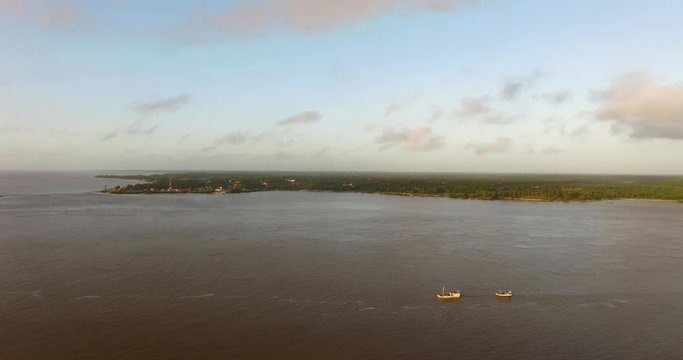 aerial view os 2 small fishing boats sailing on the Amazon River at dawn. Soure, Ilha do Marajó, Brazil