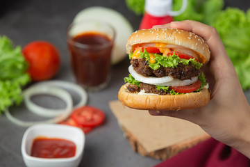 Hamburger with fried meat, tomatoes, pickles, lettuce and cheese World Food Day.