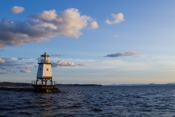 Fototapeta na wymiar Burlington Breakwater Lighthouse just before a sunset with a beautiful blue sky with clouds
