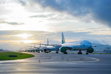 Aircraft are closely line up for long term parking at taxiway of airport due to COVID-19 