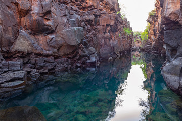 Stretch of inland crystal clear emerald green water in an earth fracture is the crevasse of Las Grietas, Santa Cruz Island, Galapagos national park, Ecuador.