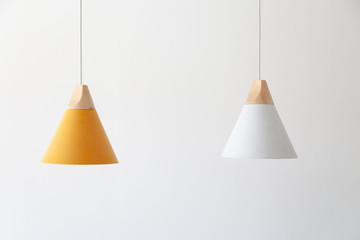 White and yellow lamps with light wooden parts are hanging on the cables - Powered by Adobe