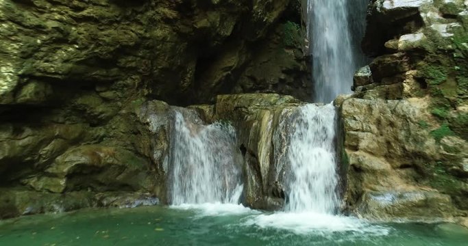 Girl admires stunning waterfall in Yahshoush, Lebanon, day, drone flying forward
