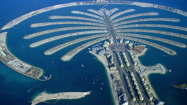 Slow pan across the Palm Jumeirah with a view of the Atlantis The Palm, the fronds, residential buildings and other resorts in the neighborhood, Aerial, 6-axis stabilized gimbal, Shotover F1, 8K.