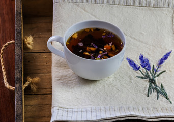 cup of tea on a wooden tray with a cloth