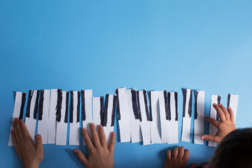 Two little children playing music at imaginary piano keyboard having fun