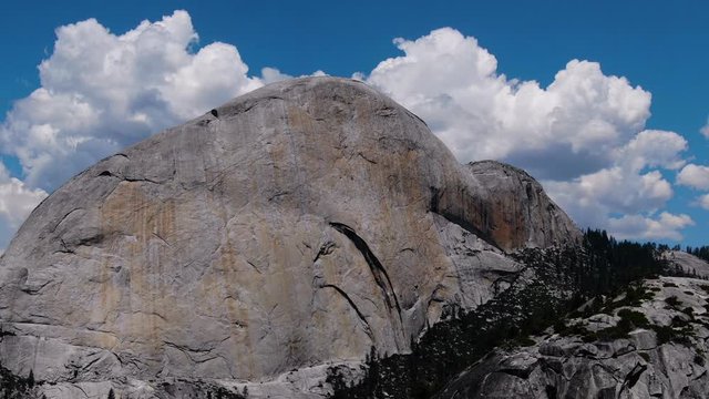 Camera moving latterly across a mountain top in front of half dome