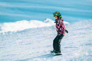 Fototapeta na wymiar Child Snowboarding in the Mountains