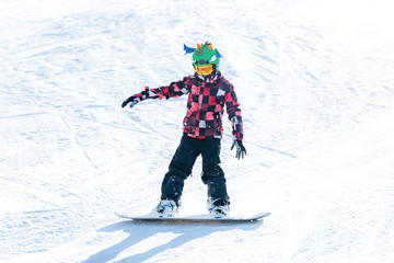 Fototapeta na wymiar Cute Boy Having Fun, Snowboarding in the Mountains