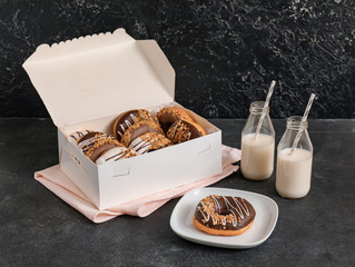 Composition with tasty donuts and milk on dark background