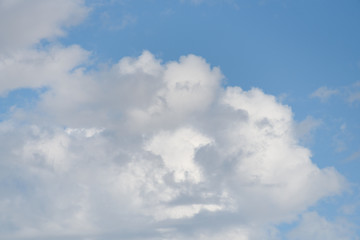 Fluffy white clouds against a blue sky as a nature background
