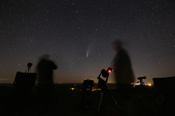 Photographers shoot a comet