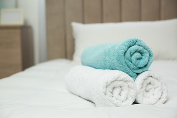 Fototapeta na wymiar Soft clean towels on bed at home
