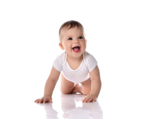 Happy laughing screaming toddler baby in diaper and white bodysuit is crawling on all fours looking...