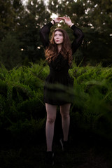 Portrait of a beautiful young girl in the forest at sunset