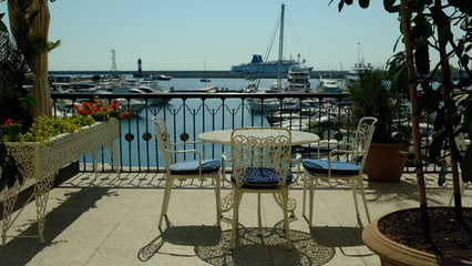 Coffee shop on the shore of the seaport, with a magnificent and romantic view of the water, yachts. Sochi, Russia. Rest on the beach. Vacation. Resort. Exclusive design. Seaport. Restaurant.