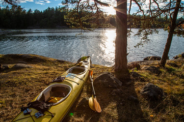 Kayak on the shore of the river in a sunset light