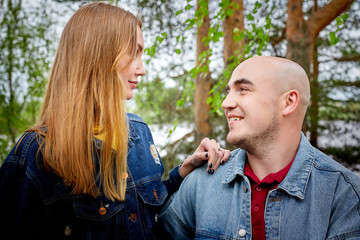 Kirov, Russia - June 22, 2020: European couple of blonde woman and bald man walking at park, enjoying and being happy together. Love and tenderness concept. Lovers on date outdoors at nature.