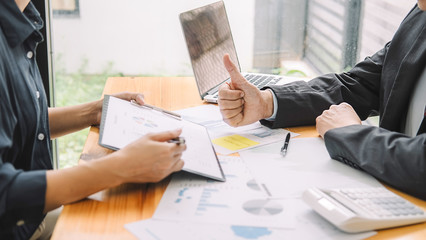 Senior businessman analyzing marketing data staff people discuss work plan pointing at papers at group meeting
