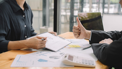 Senior businessman analyzing marketing data staff people discuss work plan pointing at papers at group meeting