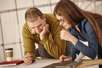 Two architects standing at a desk and discussing a project