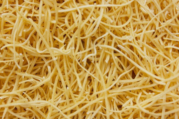Small layer of dry noodles. The food background is a pasta texture. Homemade noodles. Cooking. Background. Texture. View from above. Cooking. Copy space for text