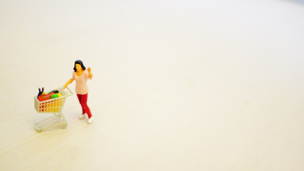 ショッピングカートを押す手を挙げた女性