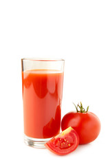 Fresh tomatoes and a glass full of tomato juice.