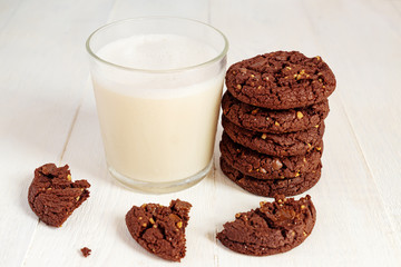 stuck of chocolate brownie cookies and glass of coconut milk on wooden background. Homemade pastry