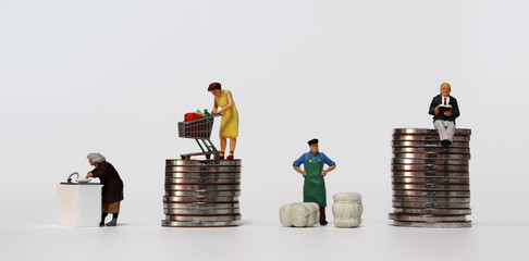 The concept of income disparity. Miniature people working on different tasks.
