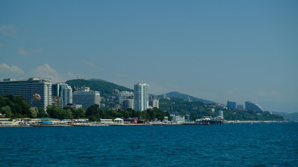 Obraz premium Panorama of the coast of Sochi in summer. Large-format. Black Sea, Russia. View from the sea. No people. Sunny day. Modern city on the beach.