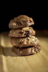 Homemade sweet chocolate cookies on wooden table with black background